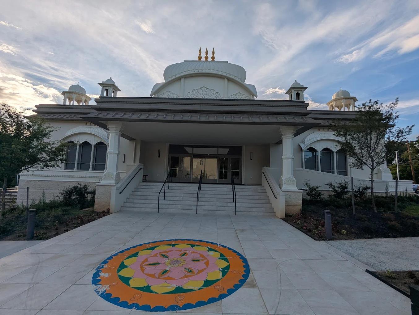 The temple facade with a coloured rangoli mandala on the entrance plaza