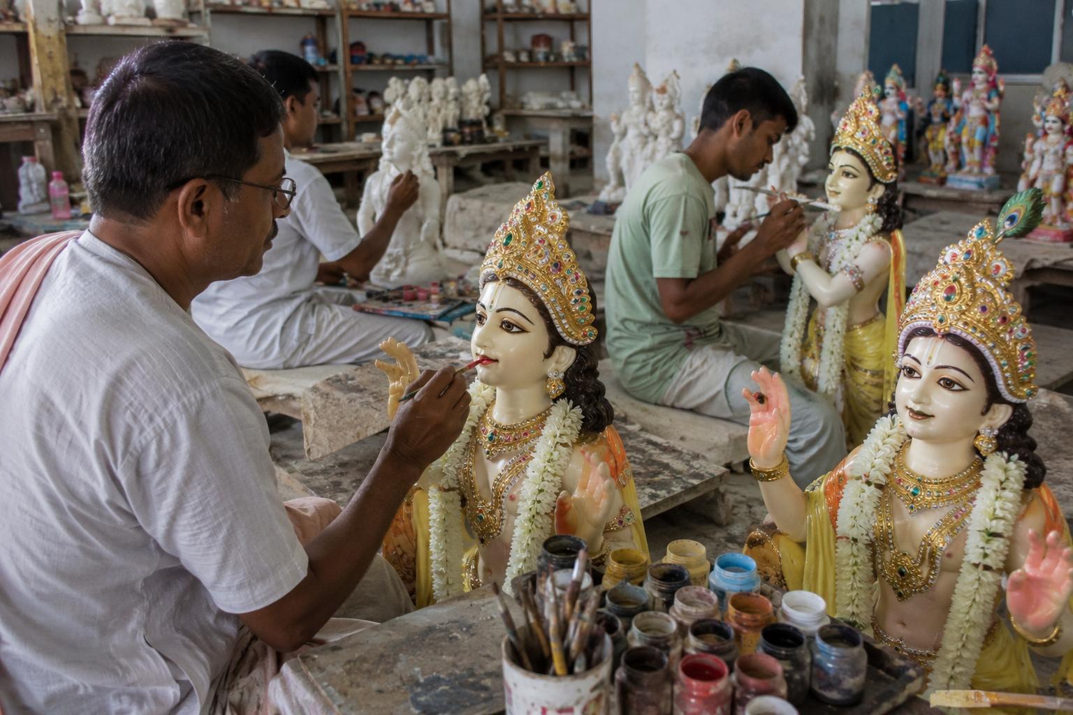 Artisans finishing and painting deity murtis in the workshop.